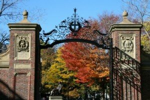 The gates to Harvard with fall foliage behind them.